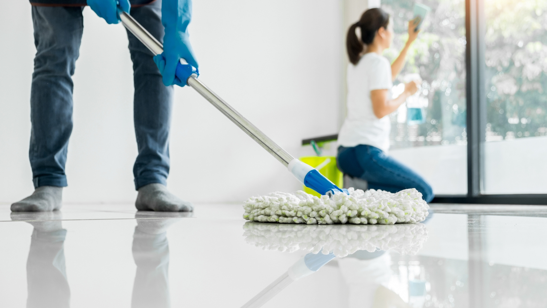 A woman is cleaning the floor with a mop